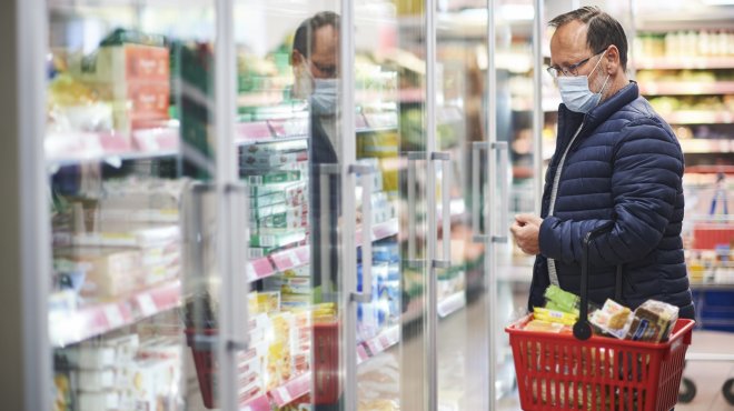 Mann beim Einkaufen mit Atemmaske