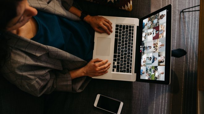 Frau sitzt vor Computer im Onlinemeeting