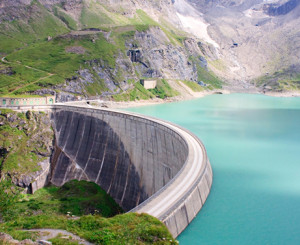 Autostrasse in der Kurve oberhalb grüner Berg unterhalb blauer See